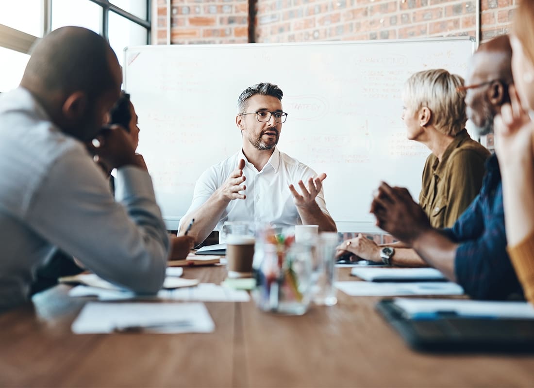 About Our Agency - Debating Before Reaching a Decision. Shot of a Businessman Leading a Meeting in the Boardroom